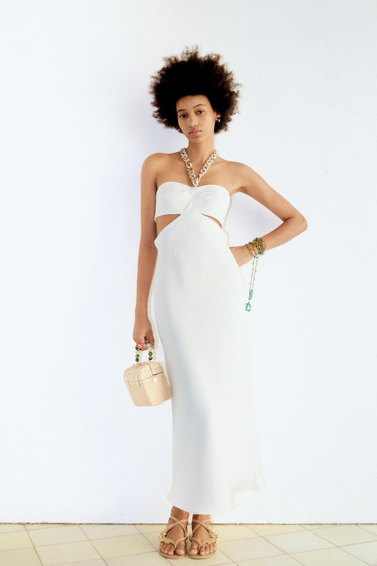 White maxi dress with cut out detail at the side and silver chain halter detail.
