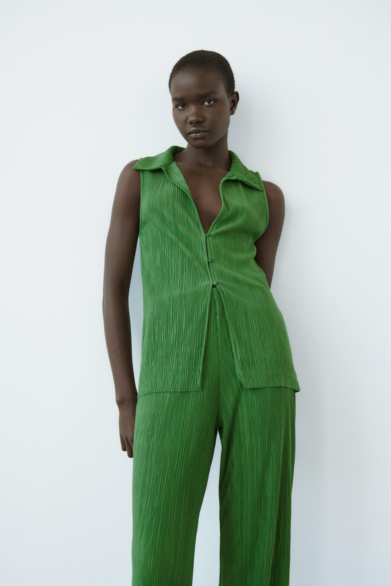 Green pleated plisse fabric longline sleeveless button-up collared top with v neck.
