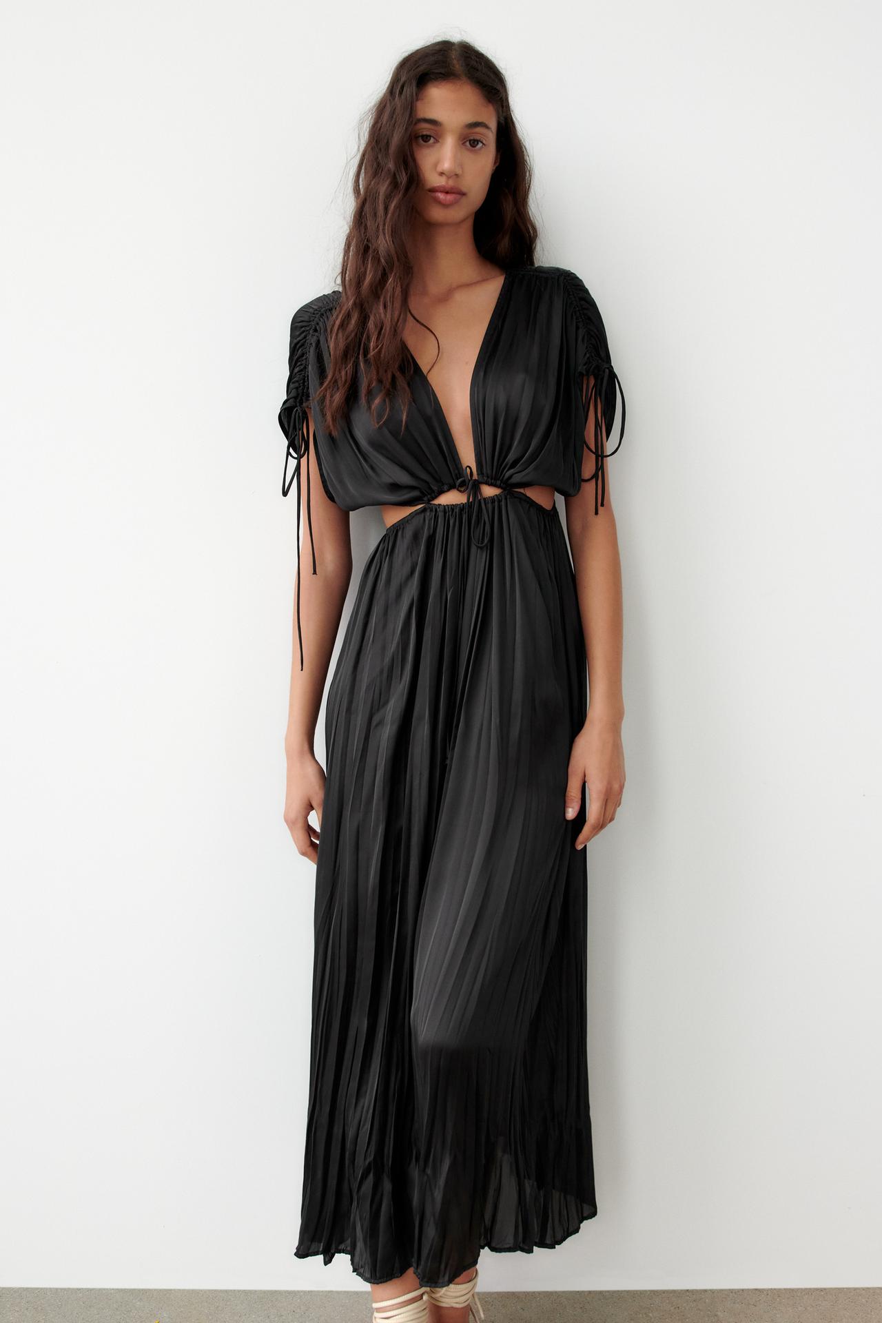 Black Satin dress with a V-neckline and short sleeves with gathered trim and drawstrings. Featuring cut-out details at the waist with elastic detail and drawstrings.
