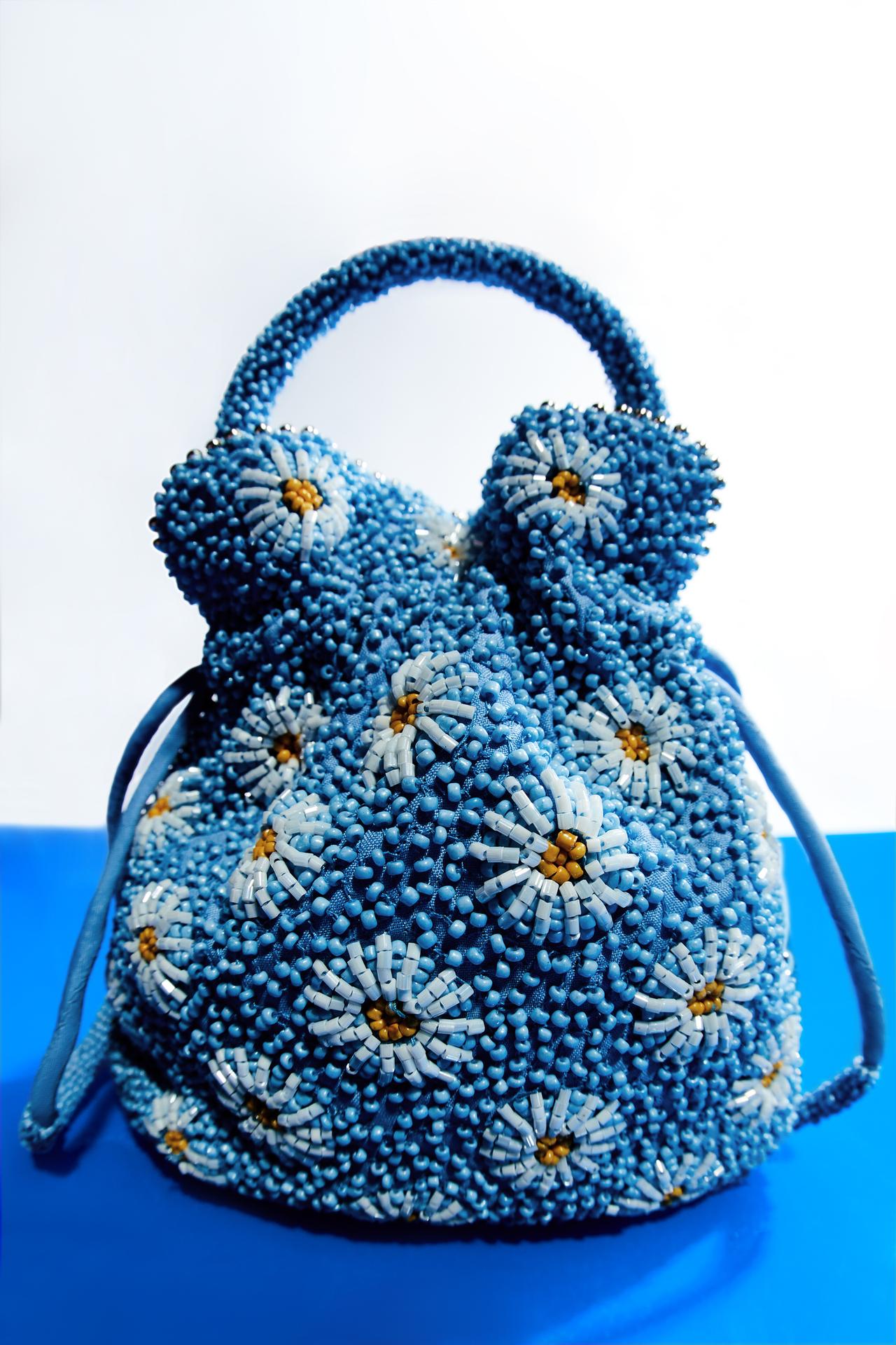 Light Blue Zara Beaded Bucket bag with beaded exterior and daisy-shaped details. Lining. Detachable beaded handle and shoulder strap. Gathered closure. Height x Width: 18.5 x 17 cm. / 7.2 x 6.6″