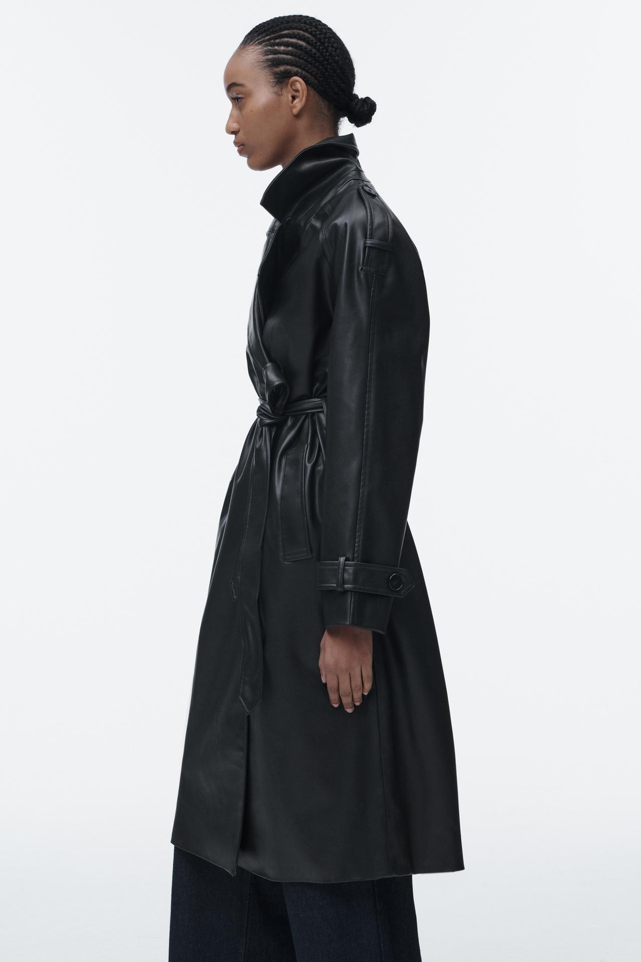 Zara faux leather belted trench coat in black. This black collared trench with long sleeves. Tab trim details. Front welt pockets, back vent at the hem, front double-breasted button fastening and a matching belt.
