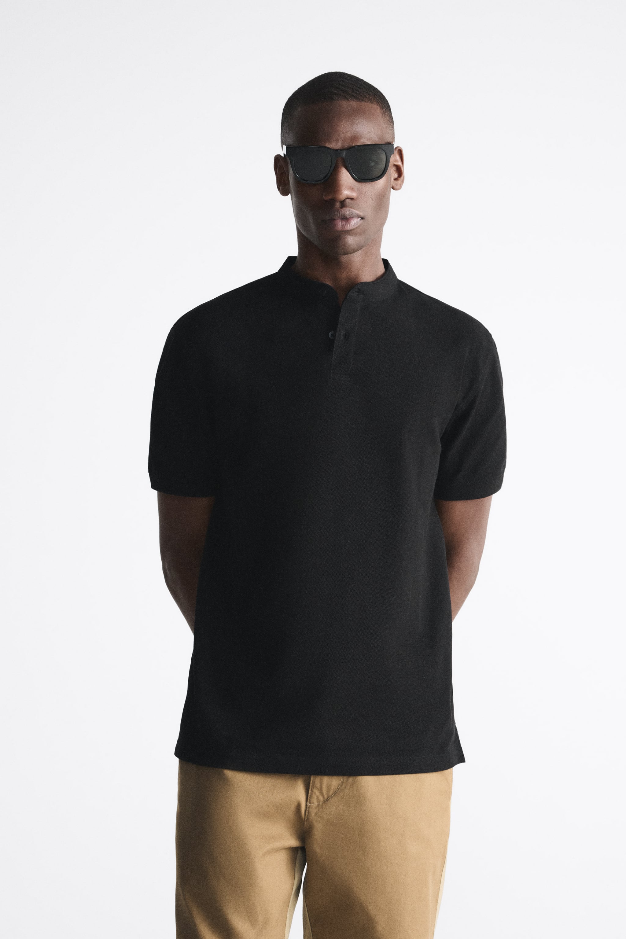 Band collar shirt with front button closure and short sleeves. Side vents at hem.
