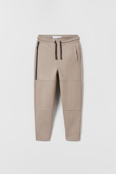 Image 0 of SPORTY RUBBERISED ZIP TROUSERS from Zara