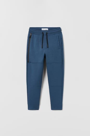 Image 0 of SPORTY RUBBERISED ZIP TROUSERS from Zara