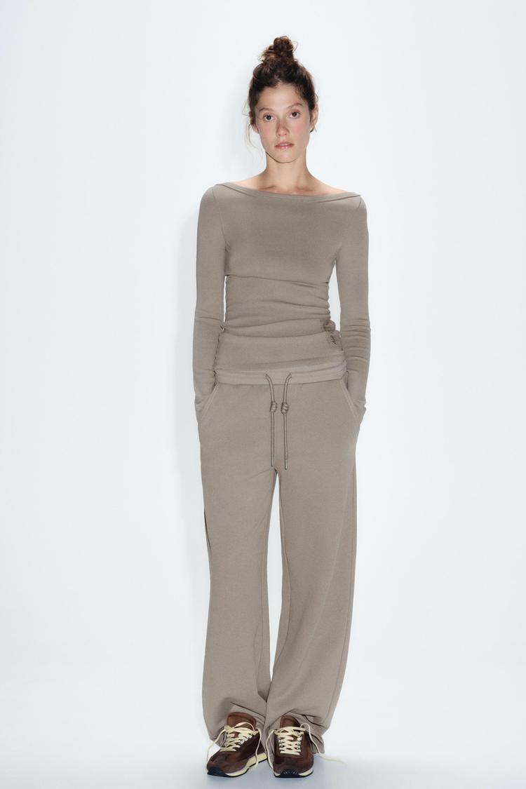 Pants with a mid elastic waist with adjustable drawstring. Front pockets. Wide leg.