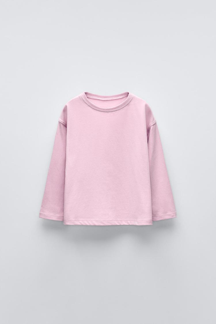 T-shirt with round neck and long sleeves. Label appliqué at back hem.