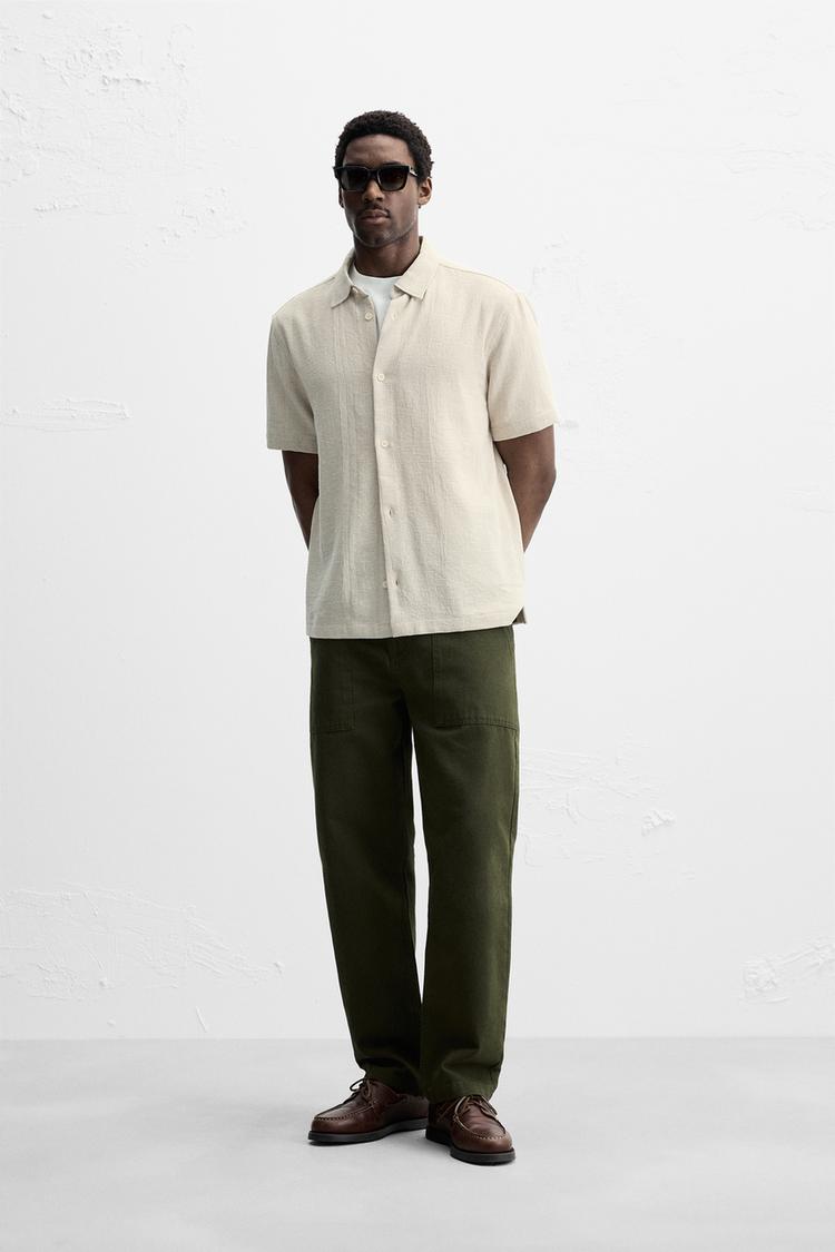 Relaxed fit shirt made of cotton blend fabric. Lapel collar and short sleeves. Side vents at hem. Front button closure.