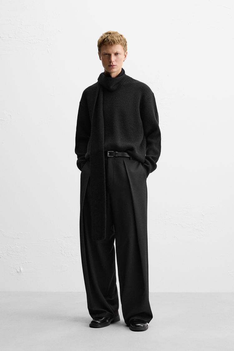 Wide fit pants. Front pleats at waist. Side pockets and back welt pockets. Front zip and hidden metal hook closure.
